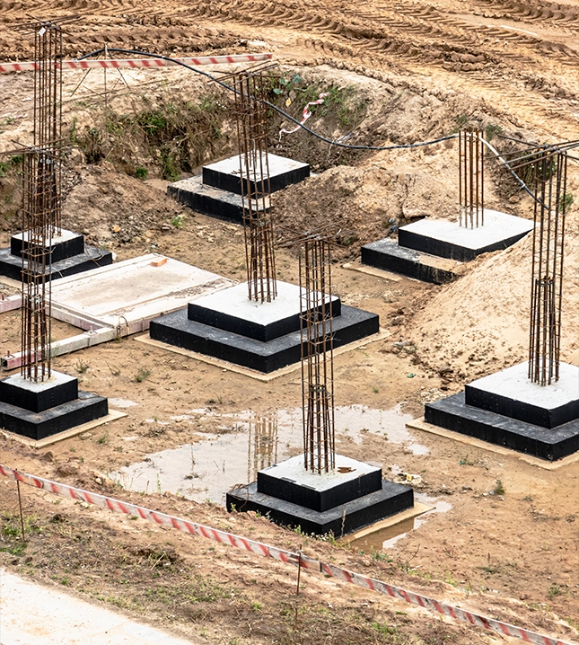 Construction Site with Concrete Pillars and Steel Rods for Foundation